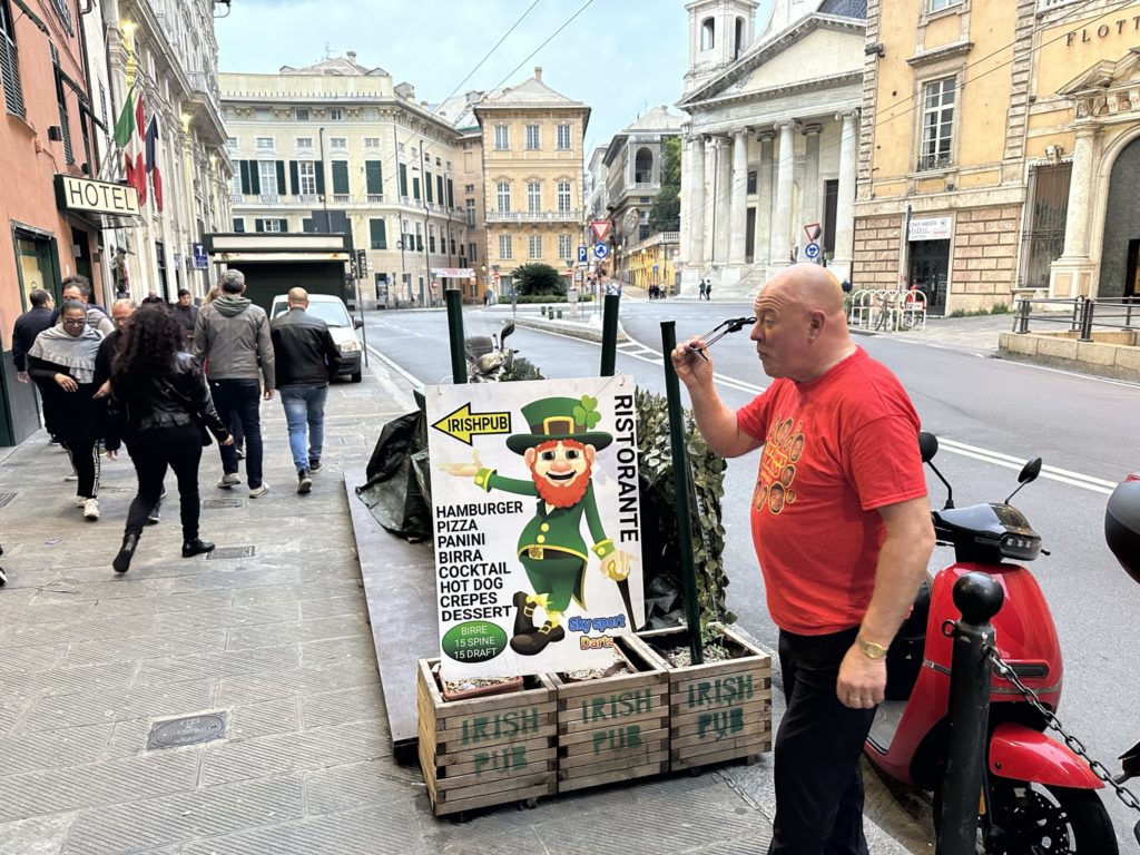Mark walking past the sign at the Irish Pub